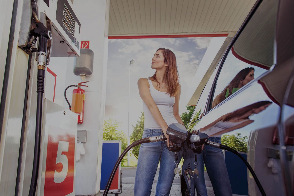 Woman pumping gas at gas station